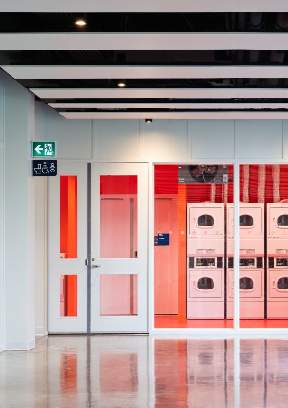 a large laundry room separated adjacent lounge and social spaces UBCO Skeena Residence by PUBLIC Architecture Studio