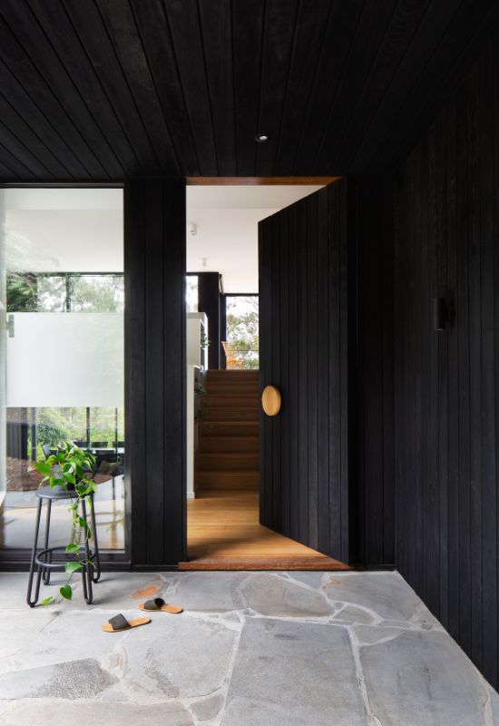 charred timber concealed door and blue stone paving The Beach House by Corke Design Studio