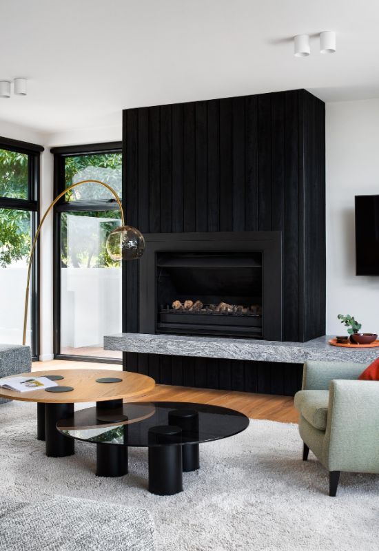 wood fireplace sitting on granite hearth The Beach House by Corke Design Studio