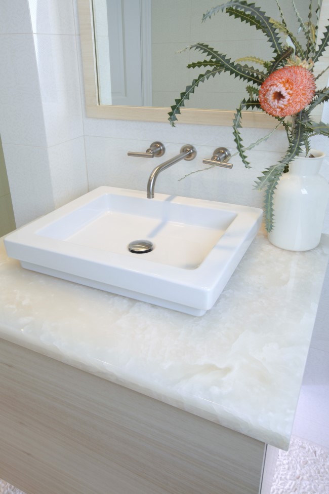 sleek white sink atop a milky onyx countertop An Ocean Inspired Home for a Family to Grow Designed by Sarah Barnard