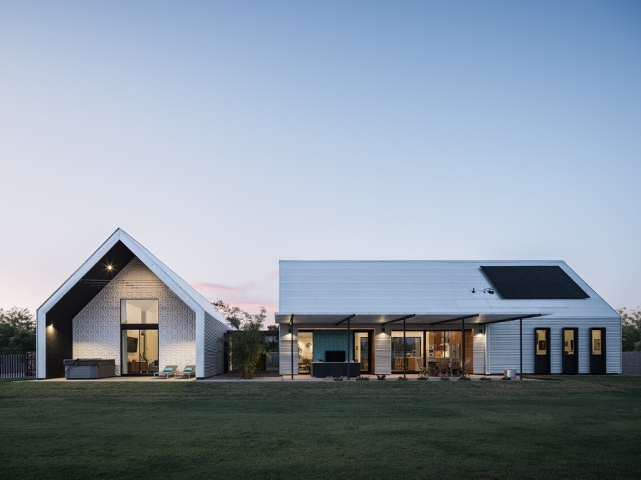 back elevation of the home at dusk A Modern Interpretation of Classic Barn Like Forms by Koss Design+Build